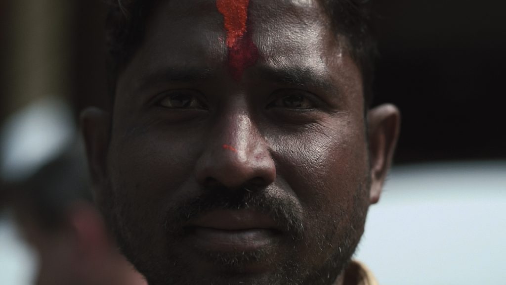close up of man with red mark on face.